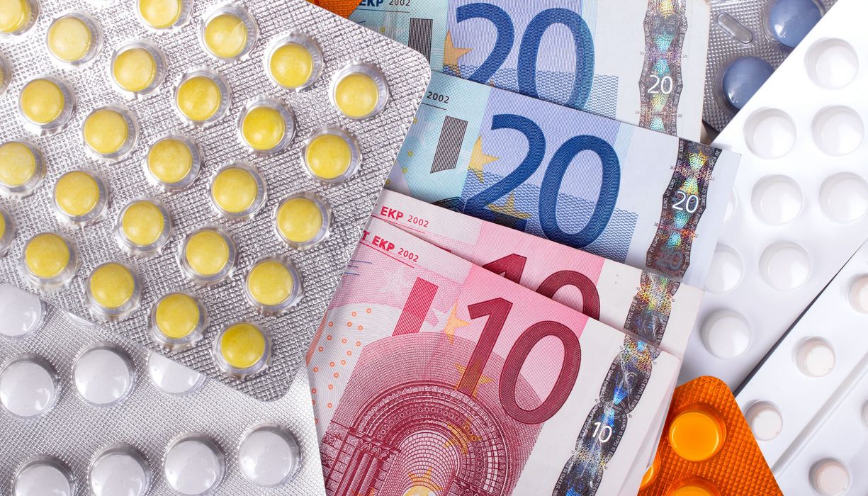10-Euro- und 20-Euro-Scheine liegen zwischen verschiedenen Tabletten in Blistern.