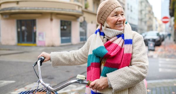 Ältere Frau mit dem Fahrrad in der Stadt.