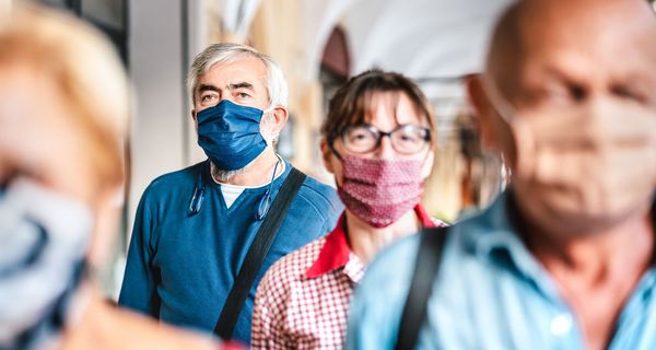 Menschen mit Maske in der Bahn.