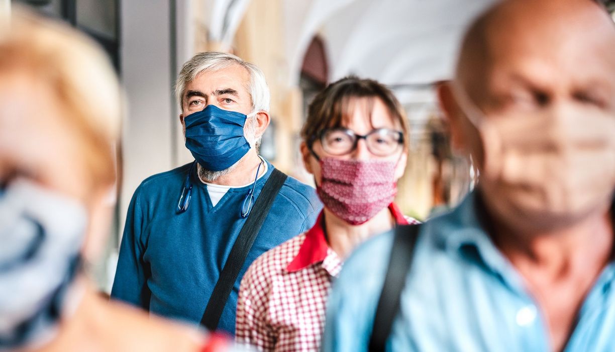 Menschen mit Maske in der Bahn.