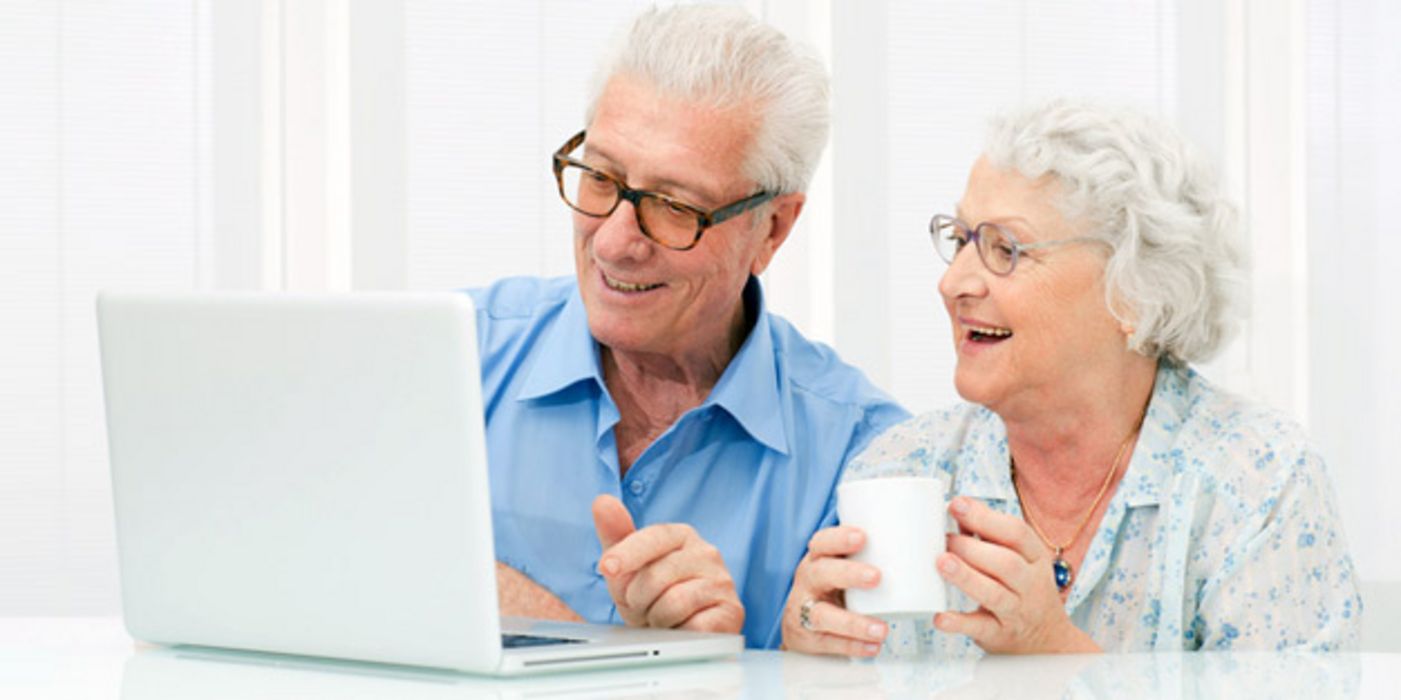 Senioren schauen Videos auf dem Computer.