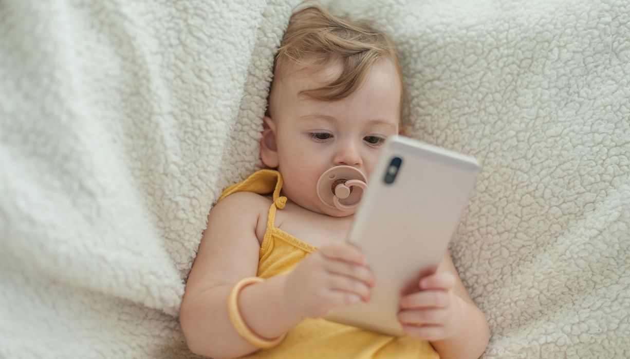 Kleines kind schaut in ein Smartphone