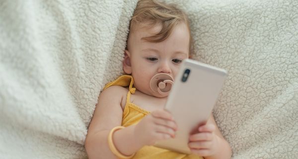 Kleines kind schaut in ein Smartphone