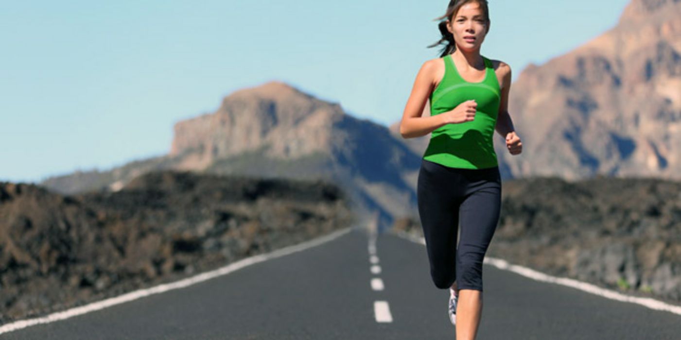 Junge Joggerin auf einer einsamen Straße