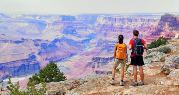 Zwei Wanderer stehen am Grand Canyon und genießen die atemberaubende Aussicht