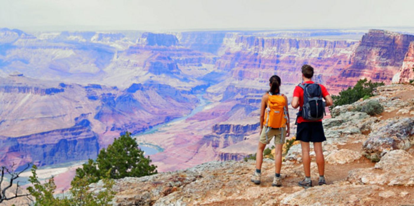 Zwei Wanderer stehen am Grand Canyon und genießen die atemberaubende Aussicht