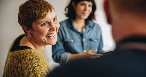 Zwei Frauen unterhalten sich mit einem Mann.