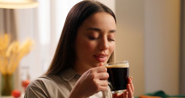 Junge Frau tritt eine Tasse Kaffee.