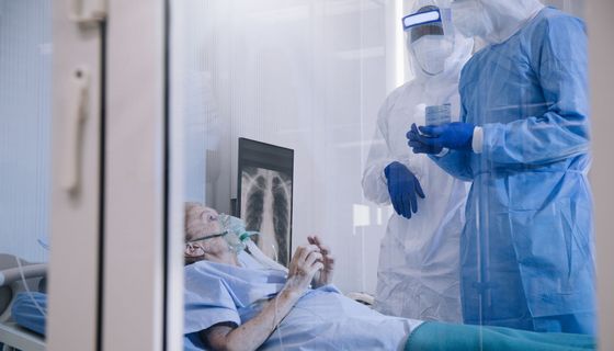 Frau, wird beatmet, liegt im Krankenhausbett.