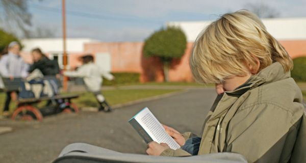 Einsamer Junge liest Buch.