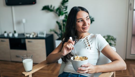Junge Frau isst Müsli.