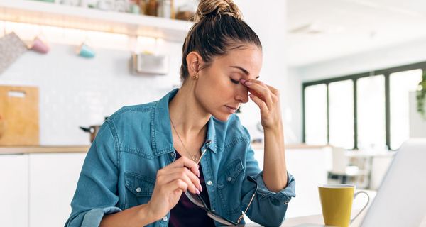 Frau vor dem Laptop hält sich die Stirn.