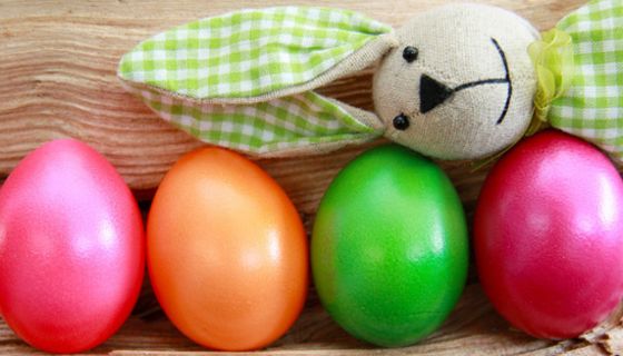 Bunte Ostereier, quer obendrauf liegt ein Stoffosterhase