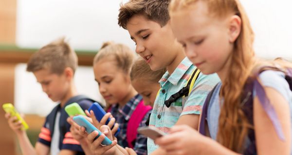 Grundschüler - Mädchen und Jungen - mit Smartphones in bunten Hüllen. 