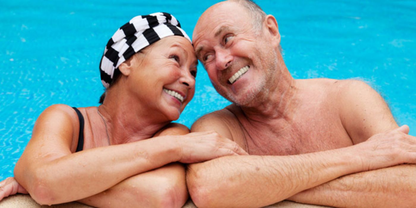 Zufriedenes Seniorenpaar am Rand eines Schwimmbadbeckens