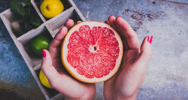 Junge Frau, hält Grapefruit in den Händen.