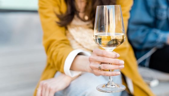 Frau, hält ein Glas Wein in der Hand.