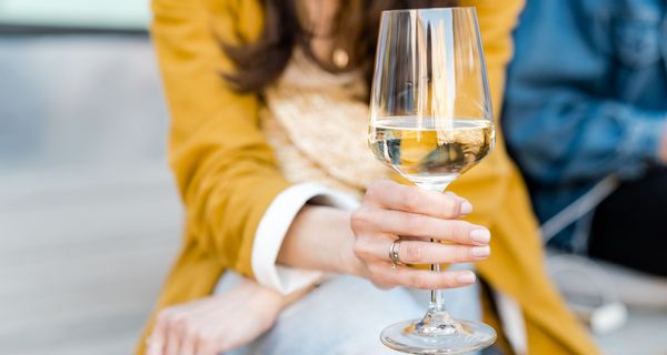 Frau, hält ein Glas Wein in der Hand.