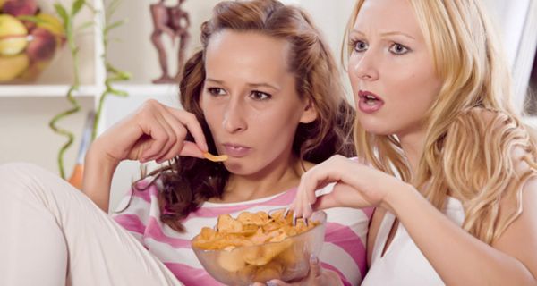 Zwei Frauen mit Chips auf dem Sofa