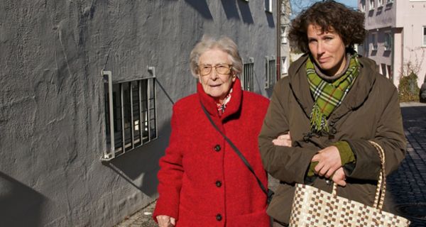 Alte Frau mit Pflegerin auf der Straße