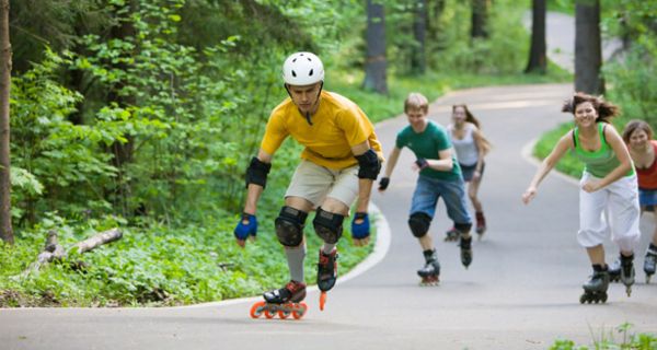 Gruppe von Inline-Skatern auf einer Straße im Wald