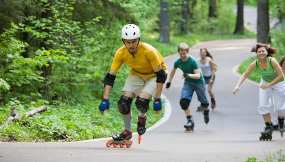 Gruppe von Inline-Skatern auf einer Straße im Wald
