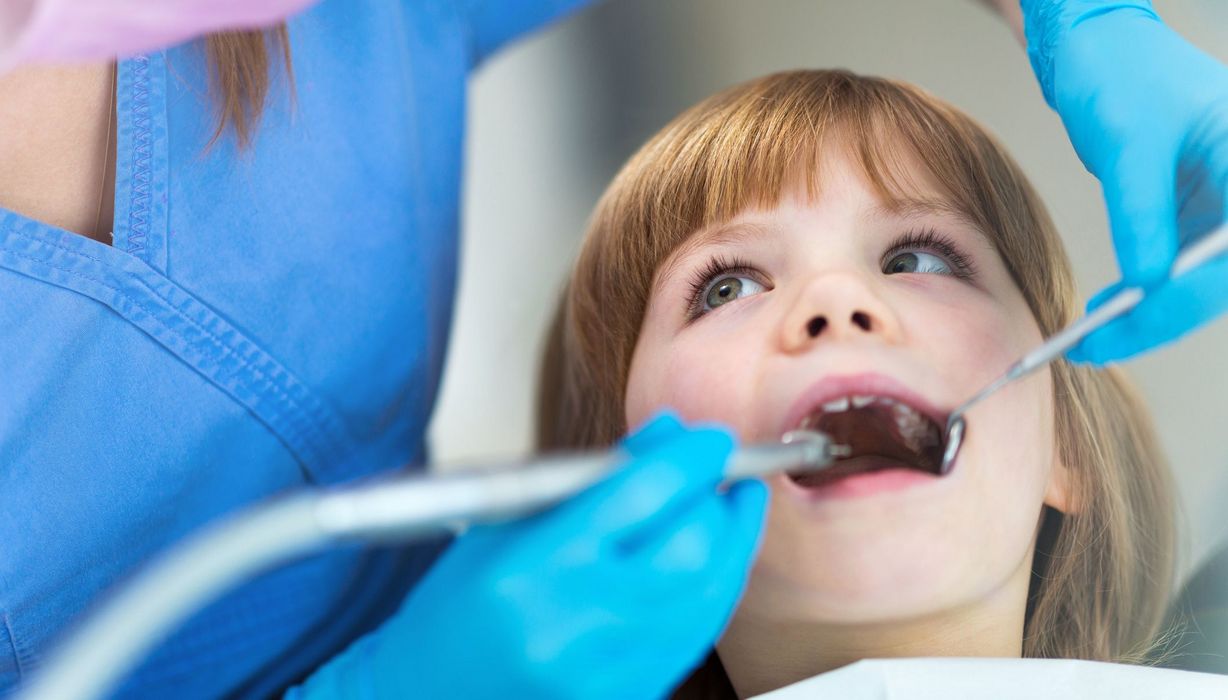 Junges Mädchen, wird von Zahnarzt behandelt.