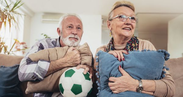 Älterer Mann und Frau beim Fußballgucken.