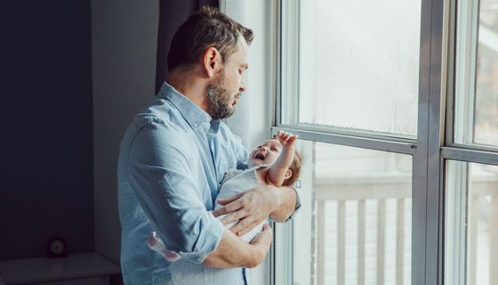 Vater, hält schreiendes Baby auf dem Arm.
