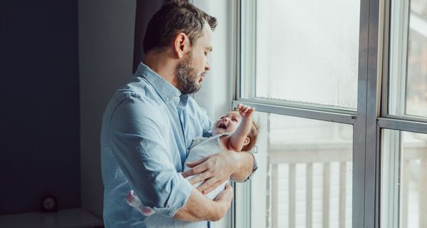 Vater, hält schreiendes Baby auf dem Arm.