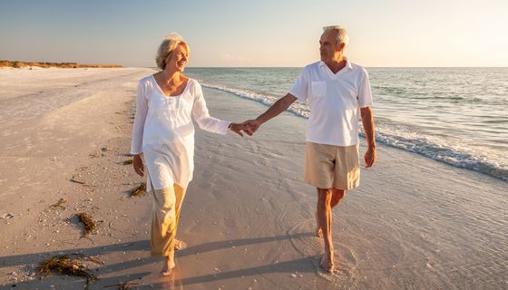 Älteres Paar, geht am Strand spazieren. 