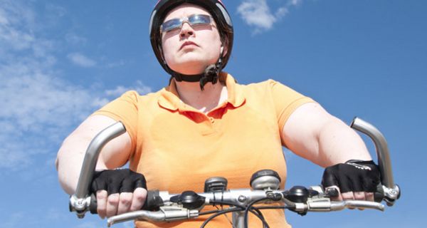 Jüngere Frau auf dem Fahrrad mit Helm.