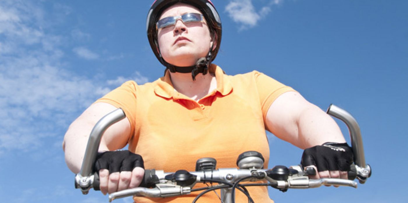 Jüngere Frau auf dem Fahrrad mit Helm.