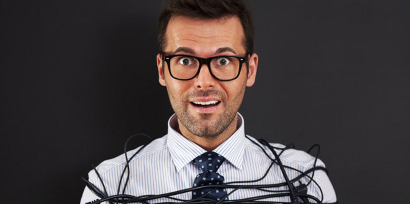 Mann mit Brille ist mit Elektrokabeln eingewickelt bzw. gefesselt