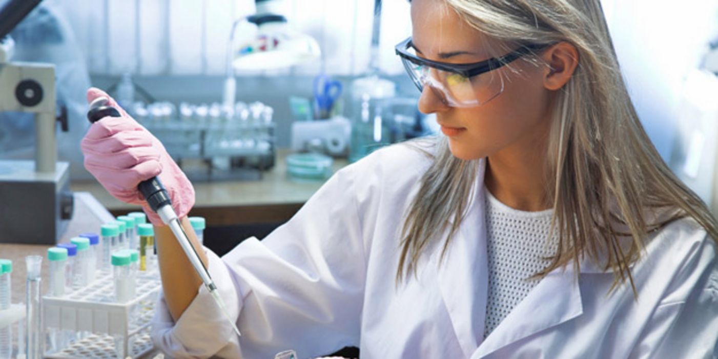 Laborantin pipettiert im Labor