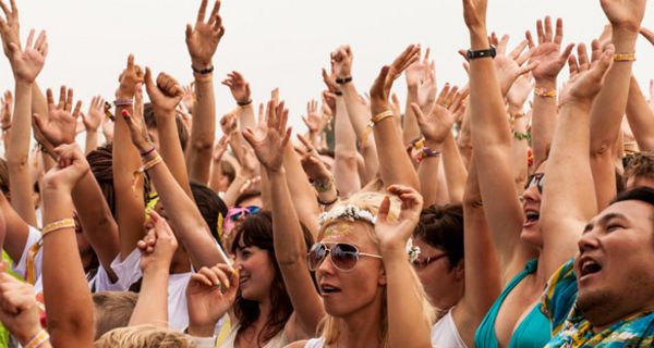 Gruppe von Menschen auf einem Konzert, die alle die Hände heben