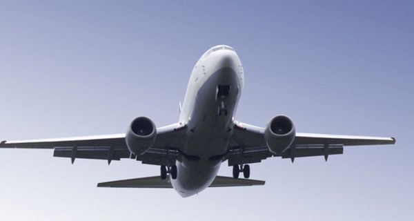 Flugzeug von unten vor blauem Himmel