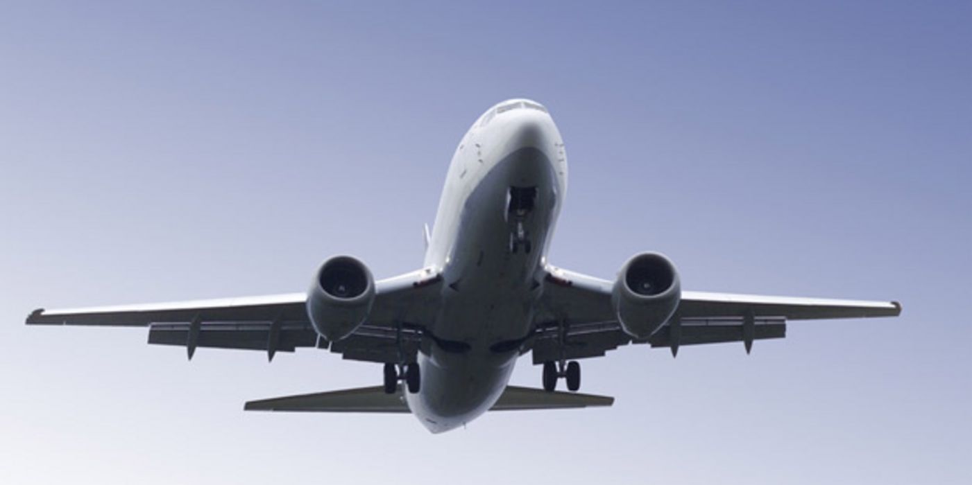Flugzeug von unten vor blauem Himmel