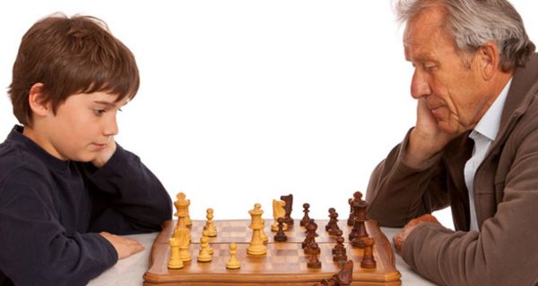 Enkel spielt mit Opa Schach.