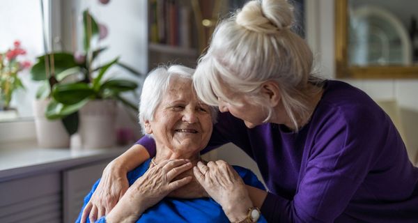 Pflegerin kümmert sich um Seniorin.