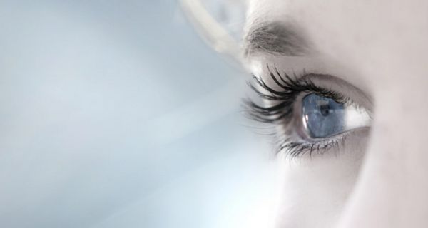Blaues Frauenauge mit getuschten Wimpern in Großaufnahme (seitlich)