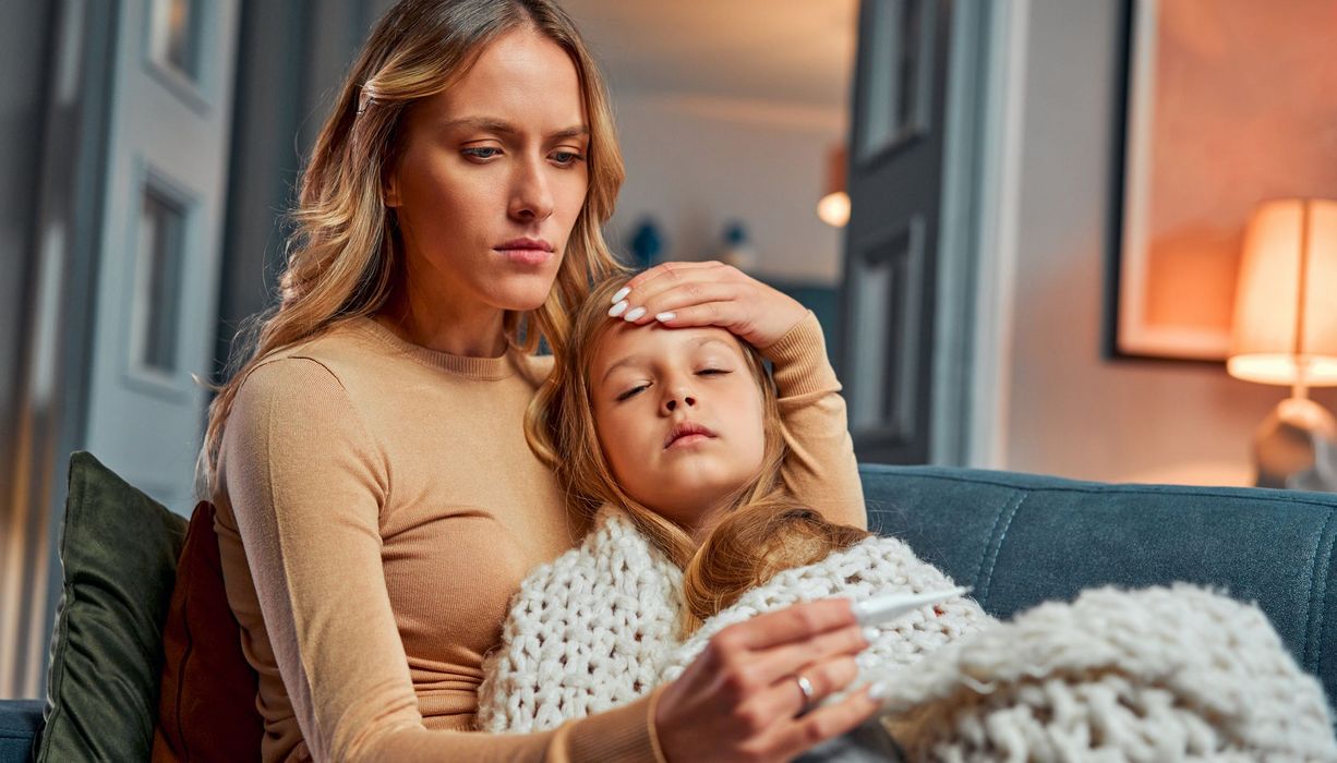 Mutter misst Fieber bei ihrem Kind.