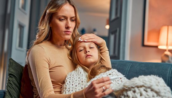 Mutter misst Fieber bei ihrem Kind.