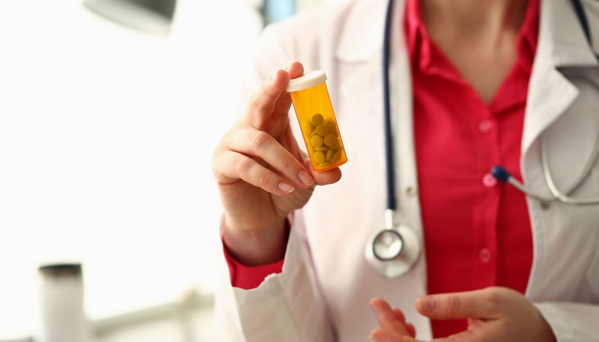 Arzt, hält eine Packung Tabletten in der Hand.