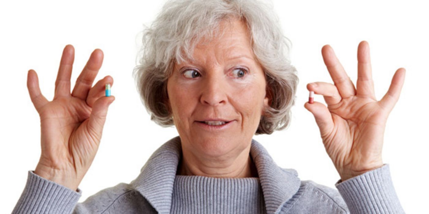 Seniorin beäugt kritisch ihre Medikamente