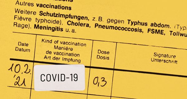 Gelbes Impfbuch mit bestätigter Covid-19-Impfung.
