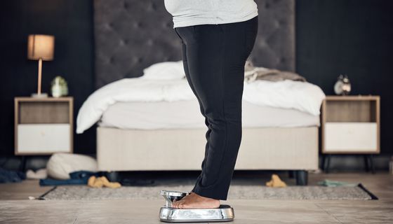 Eine übergewichtige Frau steht auf einer Waage.