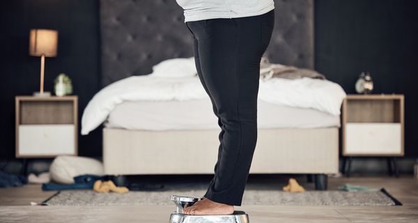 Eine übergewichtige Frau steht auf einer Waage.
