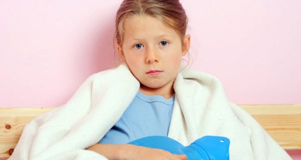 Kind mit Wärmflasche im Bett