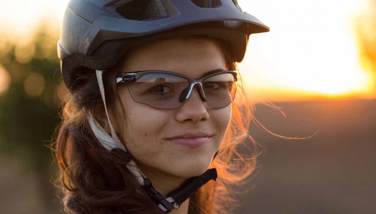 Frau mit Brille und Helm beim Radfahren.
